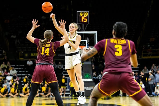 Iowa guard Kylie Feuerbach (4) passes the ball as Minnesota guard Sara Scalia (14) defends during a NCAA Big Ten Conference women's basketball game, Wednesday, Feb. 9, 2022, at Carver-Hawkeye Arena in Iowa City, Iowa