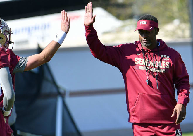 FSU coach Willie Taggart high-fives one of his players at practice.