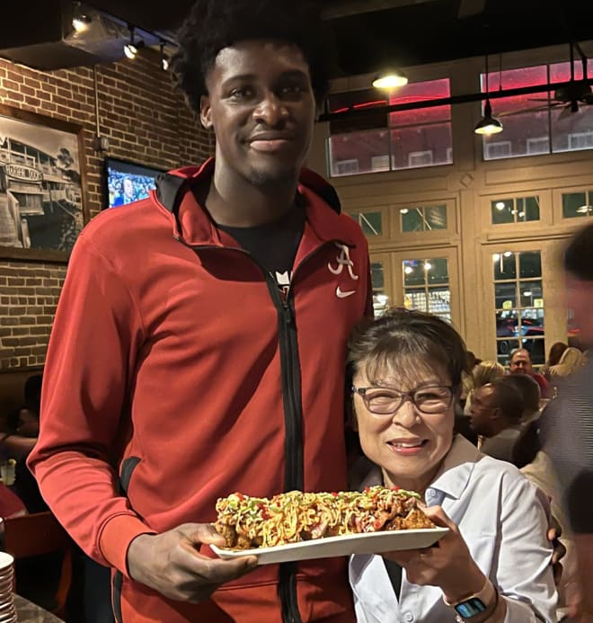 Alabama basketball center Charles Bediako (left) and Chuck's Fish sushi chef Yoshie Eddings display the new "Angry Chuck" sushi roll. 