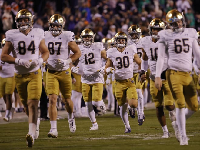 Notre Dame football players run onto the field at Virginia.