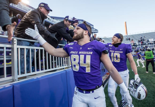 James Madison tight end Dylan Stapleton (84) and wide receiver Riley Stapleton (10) celebrate with friends and family after the Dukes' 66-21 win over Monmouth in the second round of the FCS playoffs this past December at Bridgeforth Stadium.