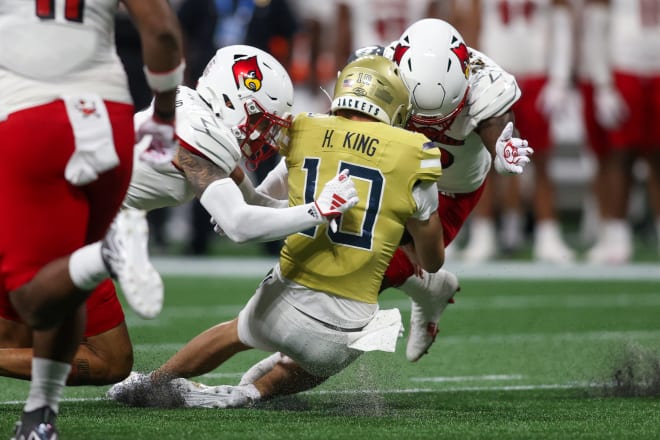 Haynes King gets hit by Louisville's Ben Perry who was ejected for targeting