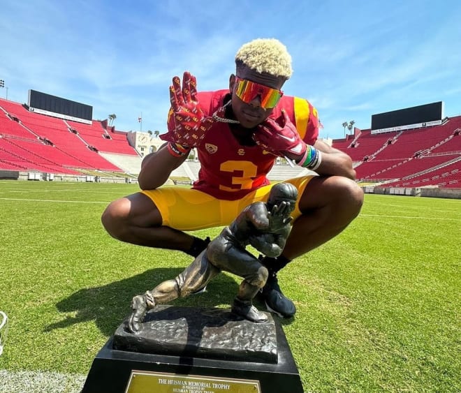Andrew Marsh poses with the Heisman Trophy on one of his previous visits to USC.