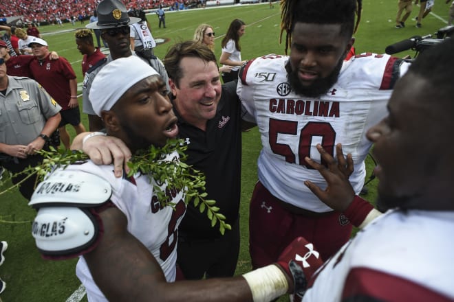 South Carolina coach Will Muschamp celebrates with players following the Gamecocks' double-overtime upset of Georgia Saturday in Athens. 