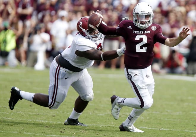 Texas A&M quarterback Johnny Manziel (2) is pressured by Alabama defensive lineman Jeoffrey Pagan (8) as he carries the ball in the first half against Alabama on Sept. 14, 2013 at Kyle Field in College Station, Texas. 
