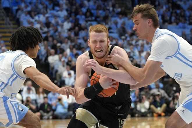 Wake Forest's Cameron Hildreth tries to protect the ball from UNC's Elliot Cadeau, left, and Paxson Wojcik. 
