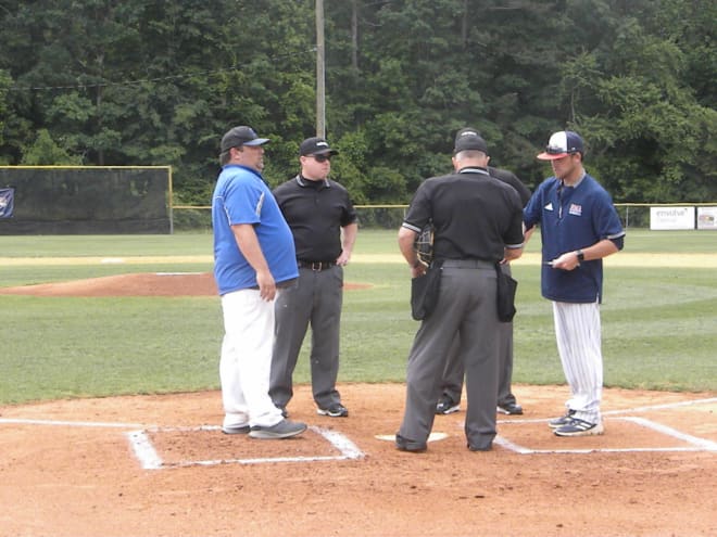 Caldwell Coach Dan Bozarth (L) & Cameron Ramsey (R) of Rocky Mount meet with the umpires