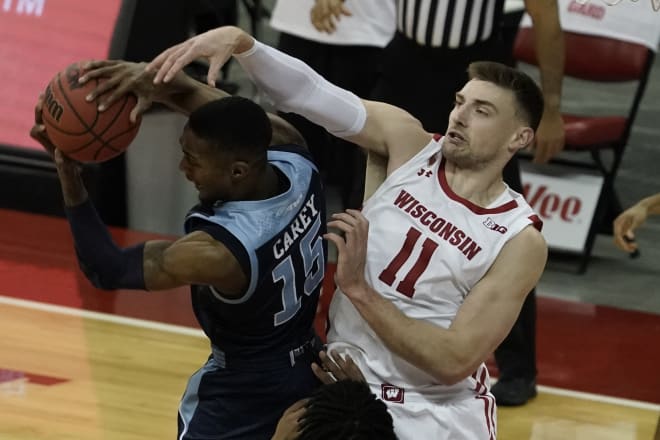 Rhode Island's Jalen Carey and Wisconsin's Micah Potter battle for a rebound during UW's 73-62 win.