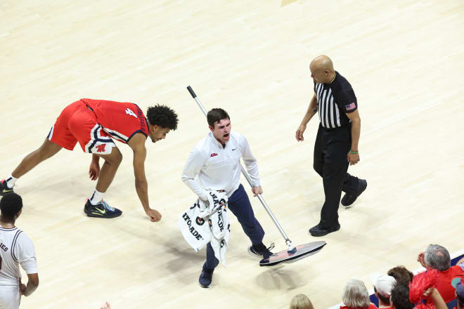 Kyle Wakefield finishes cleaning a wet spot on Craddock Court as Ole Miss forward Jaemyn Brakefield (4) looks on.