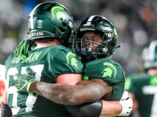 Michigan State guard J.D. Duplain hugs running back Kenneth Walker III in 2021 vs. Maryland