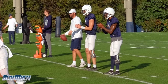 Penn State Nittany Lions football offensive coordinator Mike Yurcich (left) works with Christian Veilleux and Ta'Quan Roberson at Wednesday's practice.