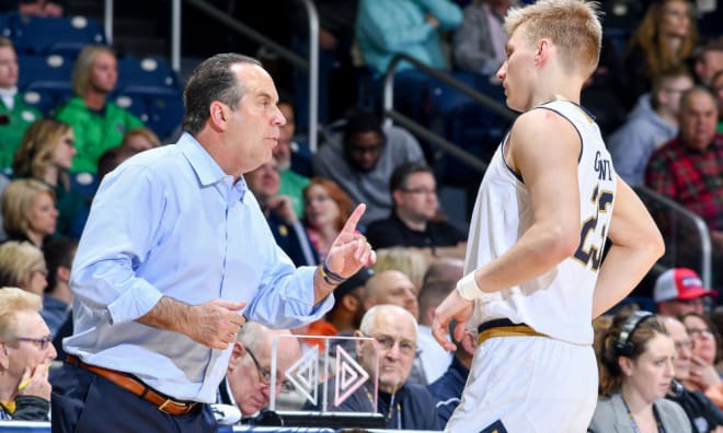 Notre Dame men’s basketball coach Mike Brey with Rex Pflueger during a game