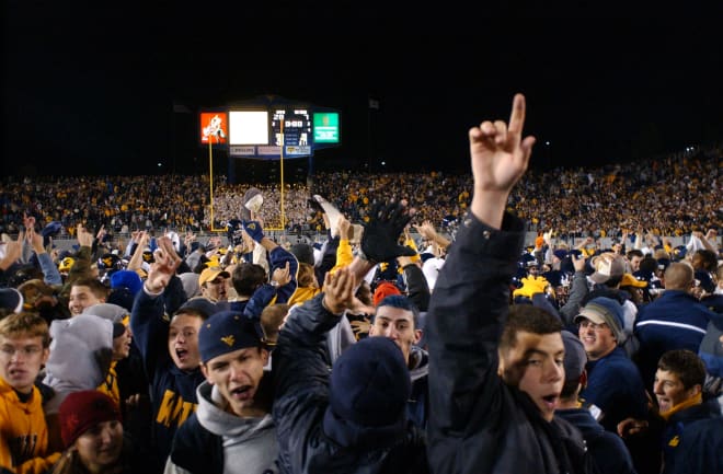 Fans quickly assemble on the field following the game.