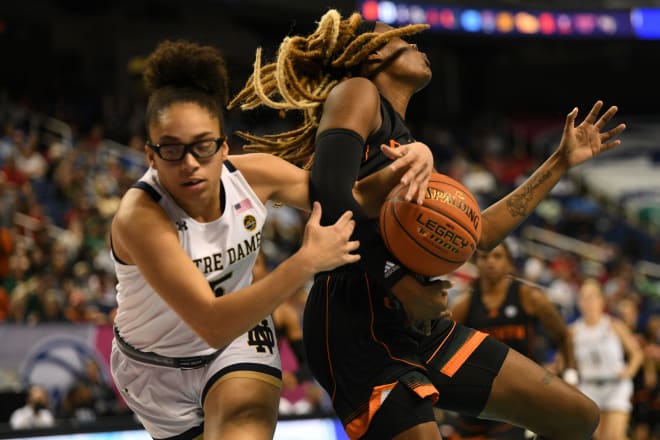 Miami forward Naomi Mbandu (35) battles for the ball with Notre Dame guard Olivia Miles (5) during the Hurricanes' upset of the Irish, Saturday at Greensboro (N.C.) Coliseum.