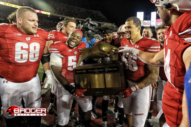 Seniors David Moorman (far left), Chris Orr (center left) and Zack Baun (right) celebrate with the Heartland Trophy in 2019.