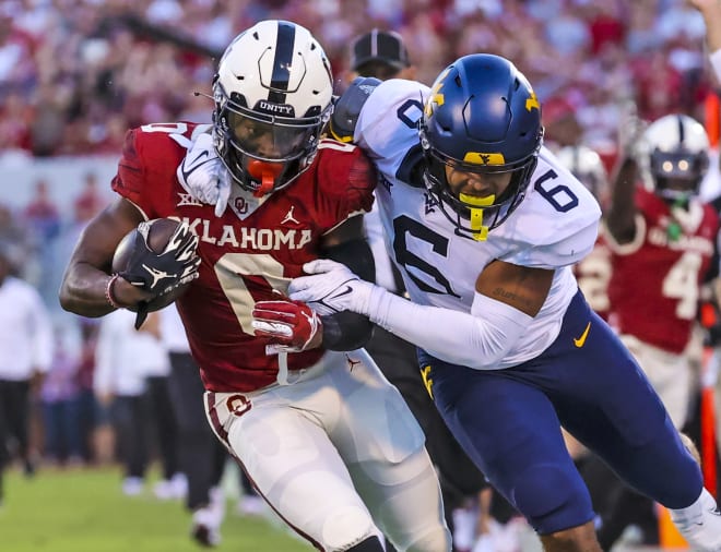 West Virginia linebacker Exree Loe (6) wrestles Oklahoma running back Eric Gray down to the ground during West Virginia's 16-13 loss to Oklahoma.