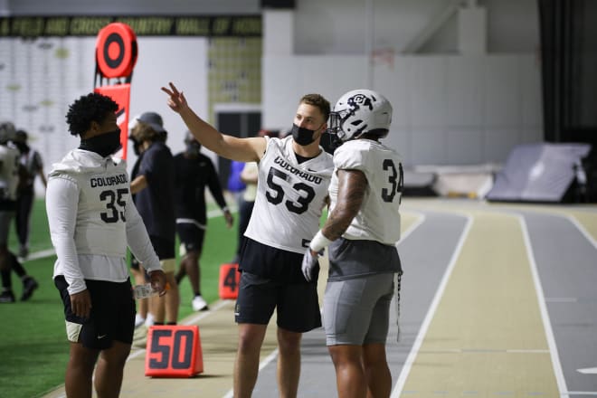 Senior inside linebacker Nate Landman shares a word with freshmen ILBs Mister Williams and Zephaniah Maea 