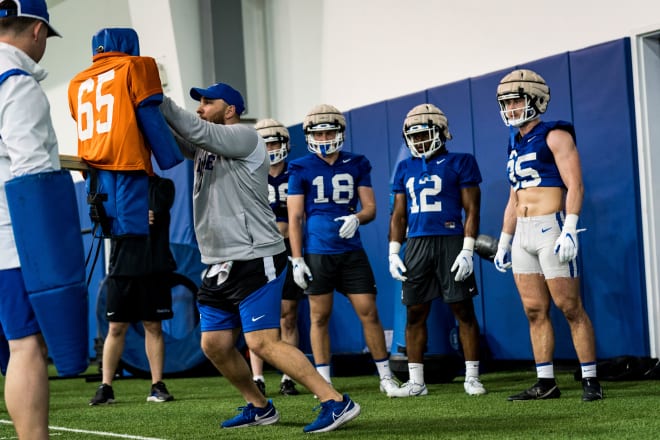 Tyler Santucci, left, goes through a drill as linebackers watch during a spring practice. 