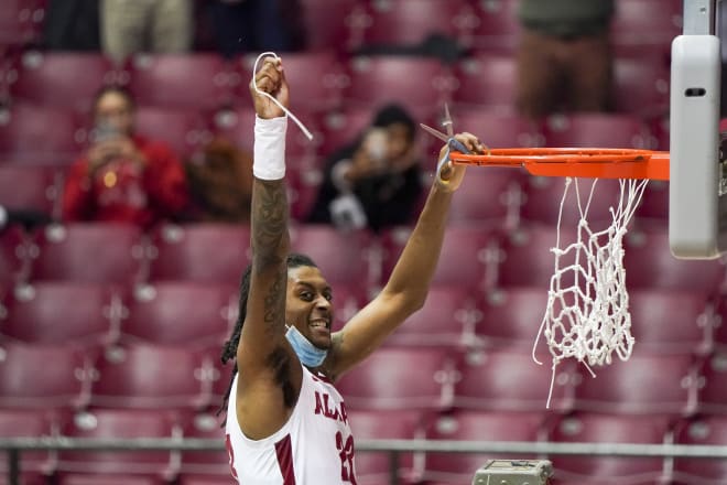 Alabama Crimson Tide guard John Petty Jr. (23) cuts down the net after defeating Auburn Tigers and winning the SEC Championship Saturday at Mississippi State at Coleman Coliseum. Photo | Imagn