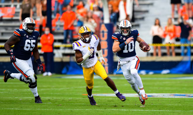 Bo Nix carries the ball with left tackle Alec Jackson trailing.