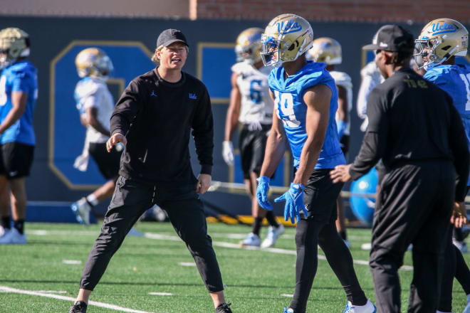 UCLA receivers coach Jerry Neuheisel, left, works with USC transfer Kyle Ford during spring camp.