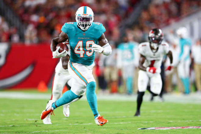 Miami Dolphins linebacker Sam Eguavoen (49) runs the ball back for a touchdown against the Tampa Bay Buccaneers in the second quarter during preseason at Raymond James Stadium