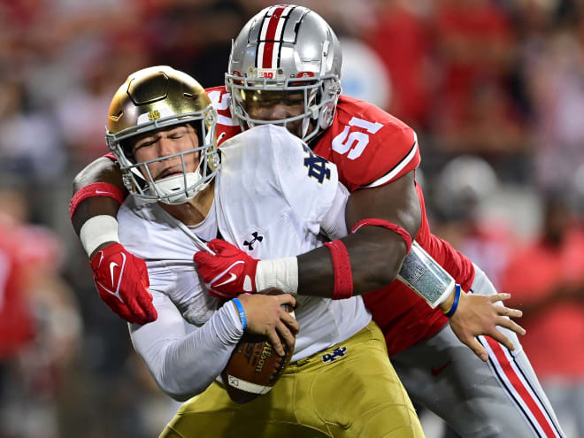 Notre Dame quarterback Tyler Buchner, in white, is sacked by Ohio State defensive tackle Michael Hall Jr.m