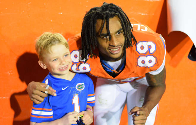 Sophomore wide receiver Tyrie Cleveland poses for a picture with a young fan