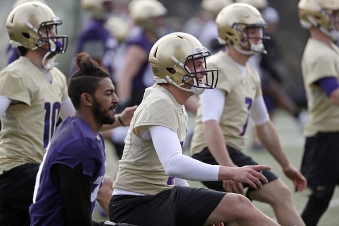 Washington quarterback Jake Browning, center, smiles as he runs through a drill with teammates at the first practice of spring football for the NCAA college team Wednesday, March 28, 2018, in Seattle. (AP Photo/Elaine Thompson)