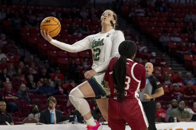 Notre Dame guard Abby Prohaska (12) shoots a layup as UMass' Ber'nyah Mayo defends during the first half of a first-round game in the NCAA women's basketball tournament, Saturday in Norman, Okla.