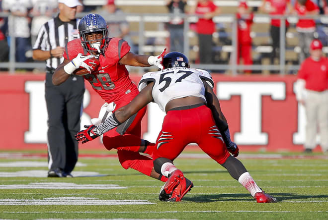 Savon Huggins, then a Rutgers running back, stiff arms a Cincinnati defender during the 2013 season (Photo: Jim O'Connor-USA TODAY Sports).