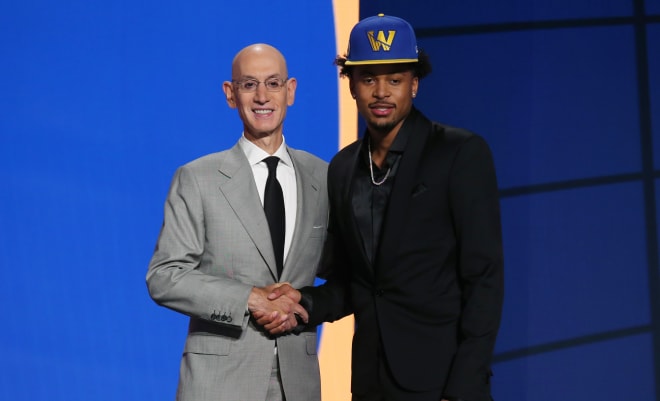 Former Razorback Moses Moody shakes hands with NBA commissioner Adam Silver during the 2021 NBA Draft.