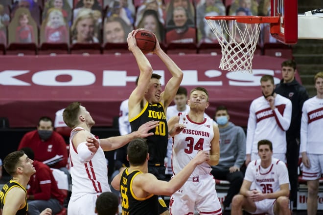 Iowa's Joe Wieskamp (10) rebounds against Wisconsin's Micah Potter, left, and Brad Davison (34) during the second half