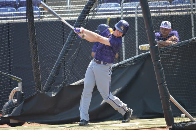 ECU's Bryant Packard takes batting practice on Thursday with head coach Cliff Godwin looking on.
