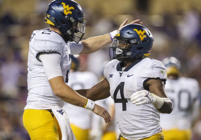 West Virginia Mountaineers running back Leddie Brown (4) runs for a touchdown and celebrates with West Virginia Mountaineers quarterback Jarret Doege (2) during the first quarter against the TCU Horned Frogs at Amon G. Carter Stadium