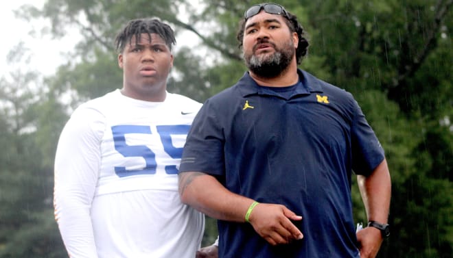 Five-star defensive tackle Walter Nolen holds a Michigan Wolverines football recruiting, Jim Harbaugh.