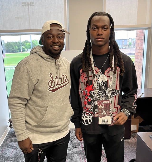 Jackson poses with receivers coach Chad Bumpis after landing an offer following the spring game in April