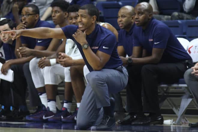Killings, to the right of Kevin Ollie, during his first season with the Huskies.