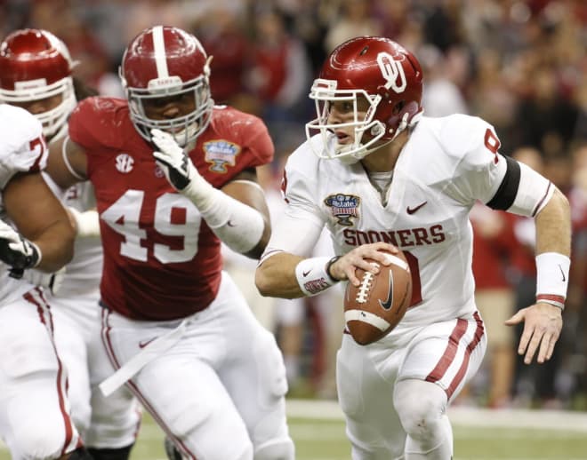 Oklahoma quarterback Trevor Knight (9) scrambles from the pocket as Alabama defensive lineman Ed Stinson (49) chases after in the third quarter at the Mercedes-Benz Superdome in New Orleans, La. on Thursday Jan. 2, 2014. Oklahoma beat Alabama 45-31 to win the 2014 Allstate Sugar Bowl.