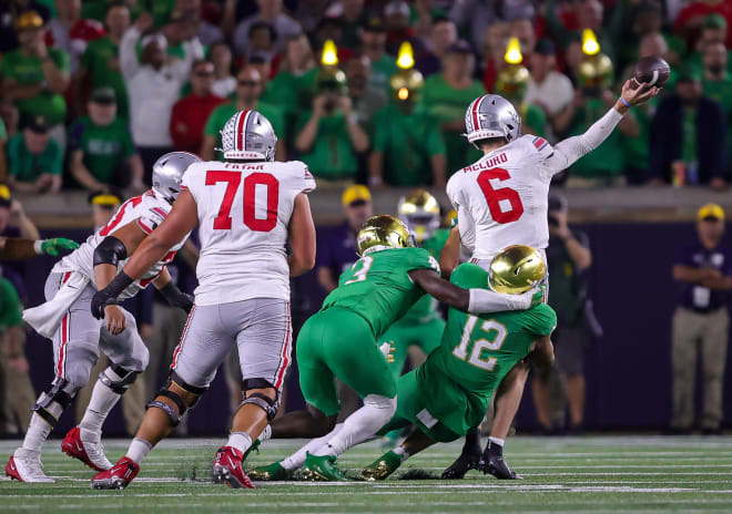Notre Dame defensive end Jordan Botelho (12) and Jaylen Sneed (3) pressure Ohio State QB Kyle McCord (6) into an intentional-grounding penalty.