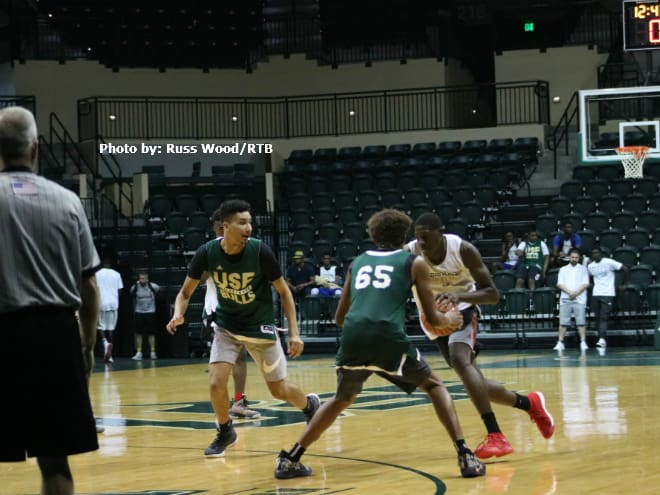 Class of 2021 forward James Henderson attempts to split two defenders at the USF Elite Camp
