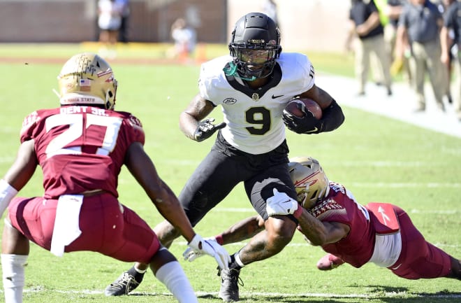 Wake Forest's A.T. Perry makes a move between FSU defenders Renardo Green, right, and Akeem Dent during Saturday's game. 