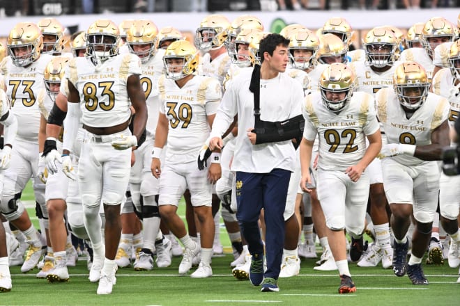 Injured Notre Dame quarterback Tyler Buchner (sling) walks off the field after warmups ahead of ND's 28-20 win over BYU, Saturday night in Las Vegas.