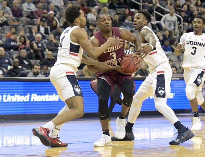 FSU guard Trent Forrest tries to fight his way through two UConn defenders on Saturday.