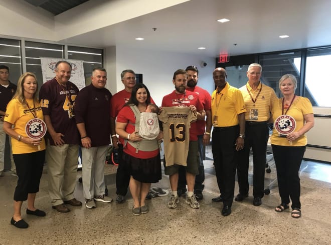 Todd Graham and Ray Anderson pictured with members of the Christopher family after they were presented an Adidas "Brotherhood" uniform with his favorite number on it