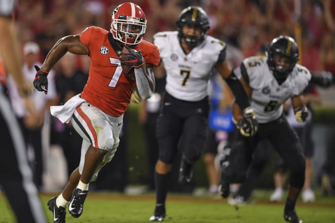 Georgia running back D'Andre Swift runs by Dimitri Moore (7) and LaDarius Wiley (5) for a score.