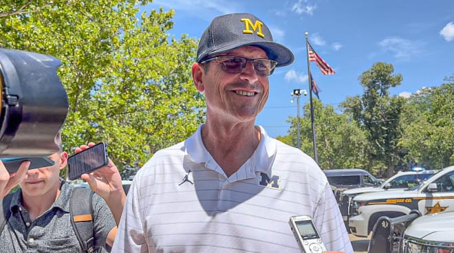 Jim Harbaugh speaks with a media scrum outside of Genesee County Jail in Flint, Mich. during Michigan football's first stop on its "Summer Tour" (Brandon Justice/Rivals)