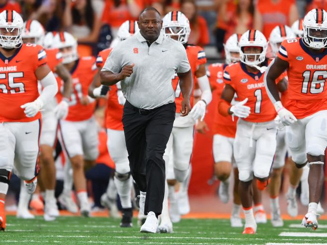 Syracuse Orange head coach Dino Babers leads his team onto the field 