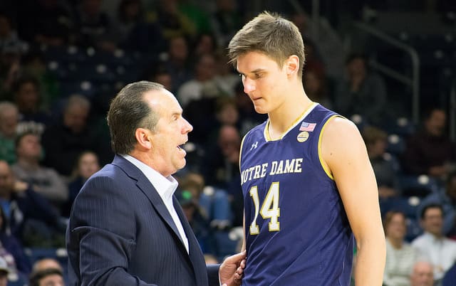 Notre Dame men's basketball coach Mike Brey talking with rising junior forward Nate Laszewski during a game