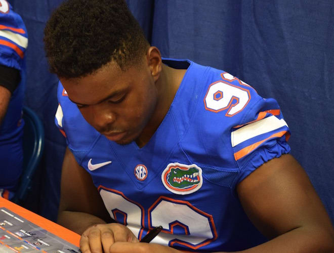 Freshman defensive end Jabari Zuniga signs an autograph during UF's fan day last August.